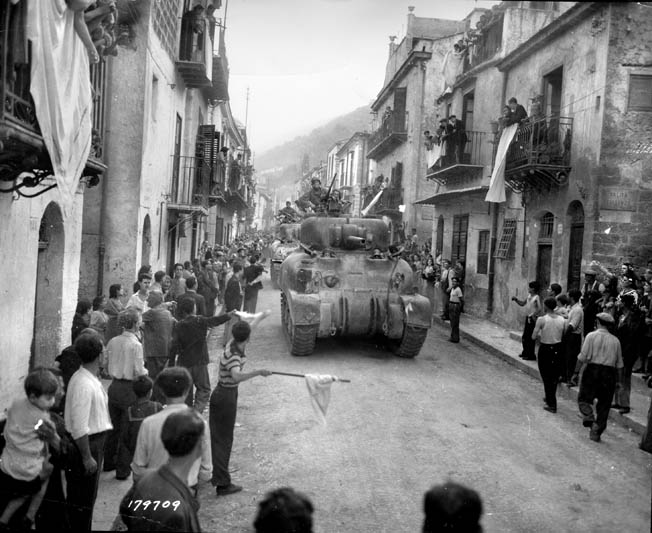 Cheering crowds greet American tankers as they roar through the streets of Palermo, Sicily. Bromberg compared entering the city to a big parade with free wine.