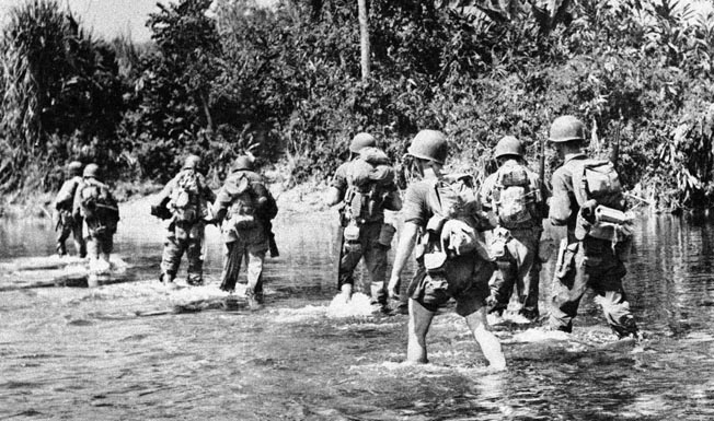 Merrill’s heavily laden men wade through a stream, March 23, 1944. The dense jungle, extreme heat and humidity, and numerous tropical diseases, not to mention the enemy, took their toll on the Marauders.