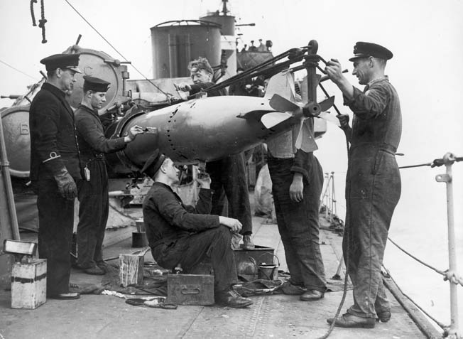 Seamen aboard a Royal Navy destroyer prep a torpedo for a launch against German U-boats, August 1941. 