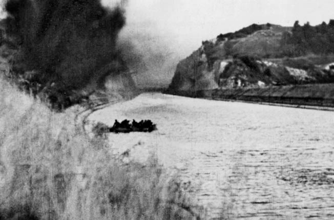 In this still photograph from the German propaganda film Sieg im Westen, or Victory in the West, Nazi soldiers cross the waters of the Albert Canal in a small boat. The action took place during the assault on Fort Eben Emael, which was thought to be virtually impregnable. The fort fell to a coordinated strike led by German glider troops.