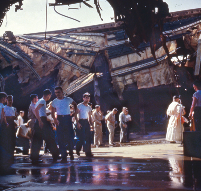 Crewmen attend church service in the ruined hangar deck of the Franklin after arriving at the New York Navy Yard in April 1945. 