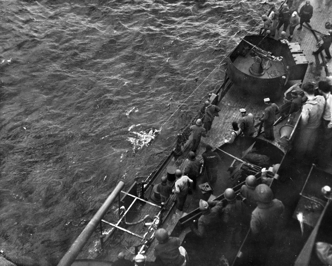 A survivor of the USS Franklin is pulled from the water by crewmen of the Santa Fe. 
