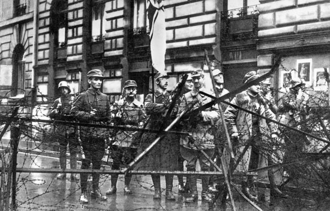 Heinrich Himmler, holding the imperial war flag, stands with other storm troopers at a Munich barricade during the Nazis’ abortive November 9, 1923, attempt to overthrow the Bavarian government.