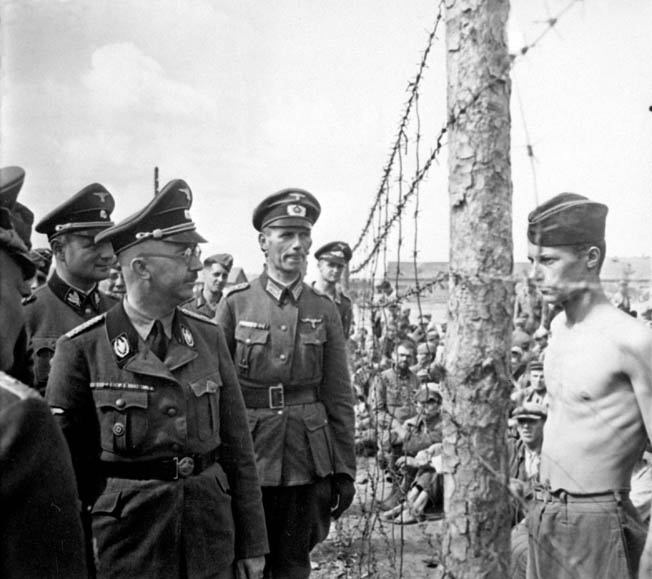 Himmler, accompanied by his entourage, inspects the Shirokaya Street camp in Minsk, Byelorussia, where thousands of captured Soviet soldiers were imprisoned, in August 1941. It was here that Himmler witnessed his first execution of a prisoner, an event that left him shaken.