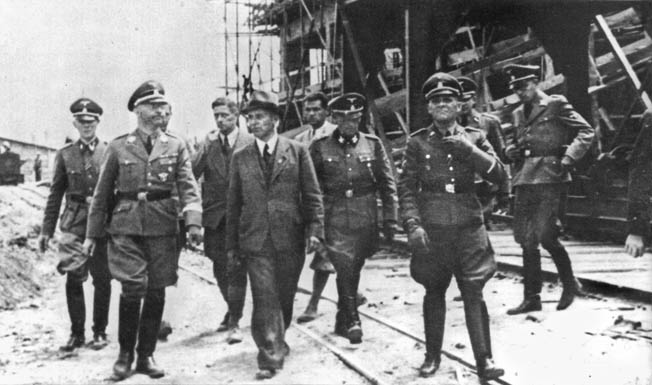 One of the Reichsführer-SS’s duties was inspecting various facilities around the Greater Reich. Here, photographed in 1942, Himmler visits the I.G. Farben synthetic fuel and rubber plant at Monowitz-Buna (Auschwitz III), where thousands of slave laborers worked. 