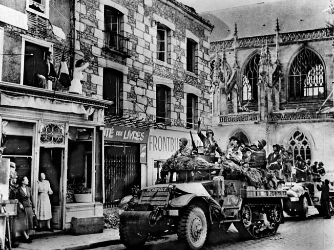 Greeted by cheering civilians, vehicles of the 2nd French Armored Division roll into Alençon on August 14, 1944.