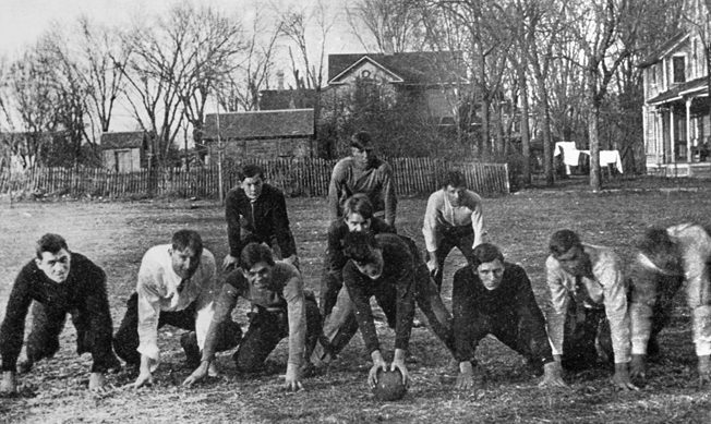 Wearing a white shirt and tie, Dwight Eisenhower (second from right) poses for a photo during a backyard football game in Abilene, Kansas (date unknown). 