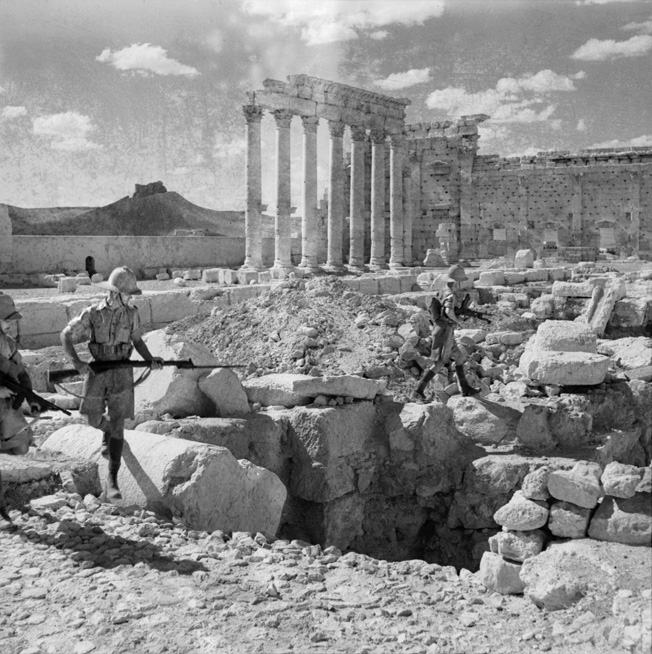 British troops search for snipers amid the ancient ruins of the Temple of Baal Shamin at Palmyra, Syria, in July 1941.
