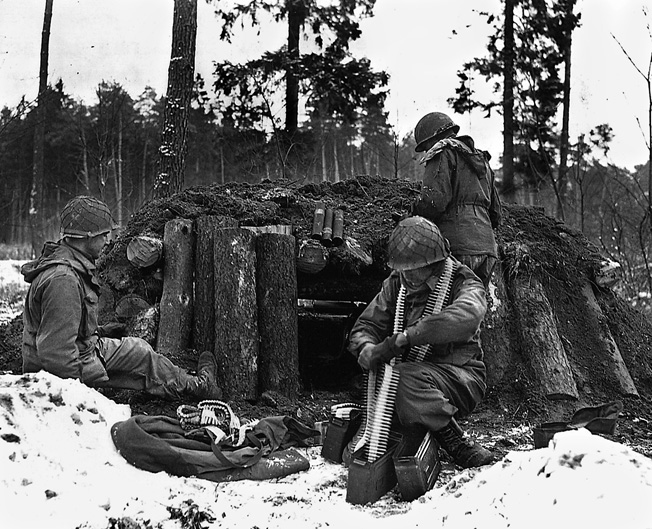 Soldiers of Task Force Linden (Company I, 242nd Regiment, 42nd Infantry Division) prepare for action at their log-and-dirt bunker near Kauffenheim, France, January 8, 1945.