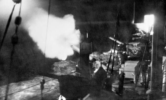 The guns of the Australian cruiser Canberra fire a salvo during a night exercise. During the Battle of Savo Island the cruiser was able to fire only a few rounds before it was so severely damaged that it could no longer participate in the fighting. 