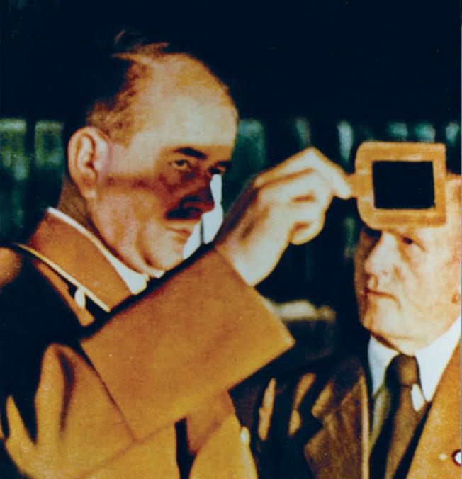 Speer protects his eyes while inspecting the process of pouring molten steel in his role as German minister of armaments and war production. 