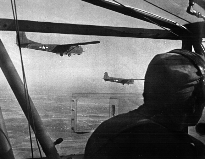 Two CG-4A Waco gliders, being towed by a single C-47, approach the release point near Wesel. Each Waco could carry 13 soldiers, a 75mm howitzer, a jeep, or a 1/4-ton trailer; 906 American gliders took part in Varsity.