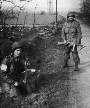 While soldiers behind them guard a road junction near Wesel, Goldie Goldman (left) and Don Manke pose with their tommy guns for Warner’s camera. Both survived the war. 