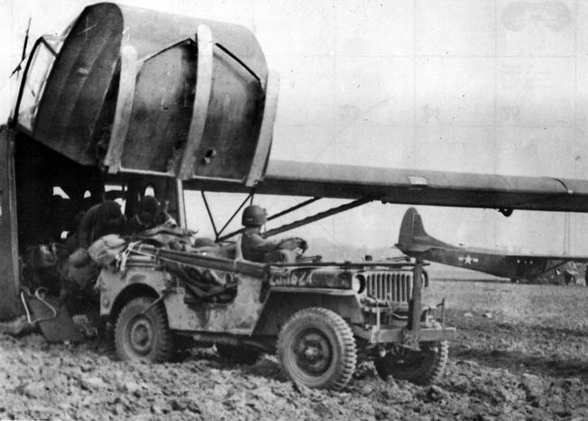 A jeep exits a CG-4A through the hinged nose fitted with Corey skids. Warner’s glider carried a jeep that had to be abandoned on the landing zone due to intense German fire.