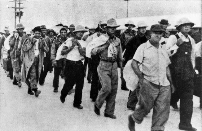 Civilian contractors are marched off to captivity after Wake fell to the Japanese, December 23, 1941. Some contractors remained to finish construction projects under Japanese occupation. Fearing a fifth-column uprising, the Japanese executed 98 contractors in October 1943—an atrocity for which the atoll commander, Rear Admiral Shigematsu Sakaibara, was hanged after the war.