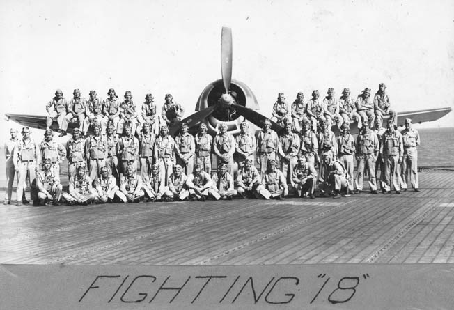 The pilots of Crosby’s Squadron VF-18 photographed with a U.S. Navy Grumman Hellcat on the flight deck of the USS Bunker Hill (CV-17). 