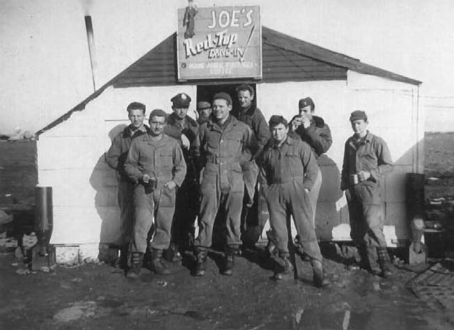 Crew members grab refreshments at “Joe’s Red Top Drive-In” between 767th Headquarters and the flight line at Torretta Field Air Base at Cerignola, Italy. Rowe (fourth from right) said, “‘Joe’ was a young Red Cross lady who always had fresh coffee and doughnuts any time we came by. I don’t know when she slept.” 