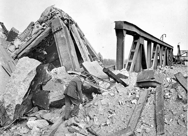 British Prime Minister Winston Churchill climbs across the rubble of a bridge over the Rhine River at Wesel, Germany, on March 25, 1945. As Churchill moved forward, General William Simpson, commander of the U.S. Ninth Army, warned the prime minister that German snipers were still quite active in the area. 