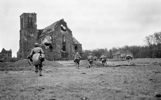 104th Division troops advance past a bombed-out cathedral in Eschweiler, a few miles east of Aachen, on their way to Weisweiler. Creamer was appalled by the destruction he saw—and caused.