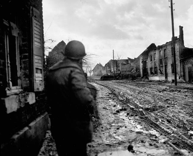 A soldier from the 104th cautiously advances toward a knocked-out panzer sitting in the middle of Lamersdorf. The town had been heavily shelled by American artillery before the 104th seized it. Creamer said he was frightened by a King Tiger tank in the nearby town of Lucherberg.