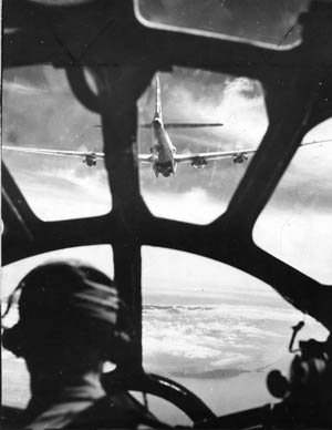 View from the bombardier’s position in the nose of a B-29. The lead plane has its bomb-bay doors open as the Japanese coast comes into view.
