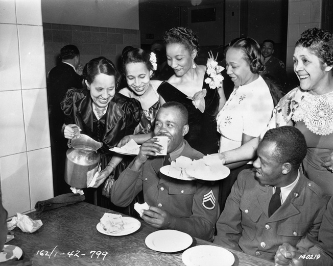 Black USO hostesses serve African American soldiers of the 2nd Cavalry Division at Camp Funston, Kansas. Because of segregation, the USO had to provide separate facilities for black and white troops. 