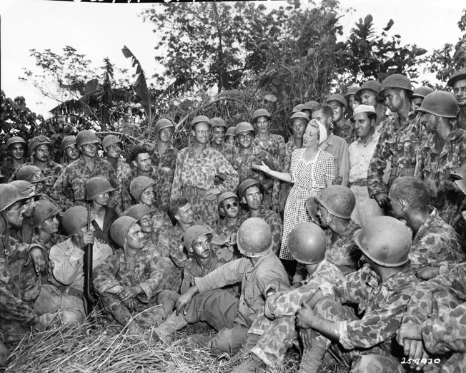 Songstress Martha Tilton, a vocalist with Benny Goodman’s band and a member of the Jack Benny Troupe, entertains a rapt audience of soldiers of the 222nd Field Artillery Battalion on New Britain, July 1944. USO performers often risked their lives to bring smiles and a touch of home to troops stationed around the globe. 