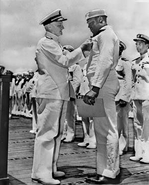 Admiral Chester W. Nimitz, the U.S. Navy commander in chief in the Pacific, pins the Navy Cross on Seaman Dorie Miller during a ceremony at Pearl Harbor on May 27, 1942.