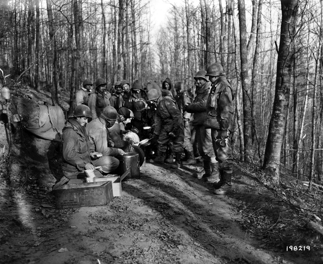 Christmas Eve dinner at the front: men of the 399th Regiment line up to receive hot chow—a rare treat. 