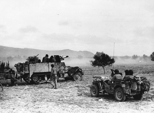 Early in the war in the North African desert, half-tracks armed with 75mm cannon served as tank destroyers and mobile artillery. Here, medical personnel rush to the aid of a soldier who has been wounded in combat with Axis forces.