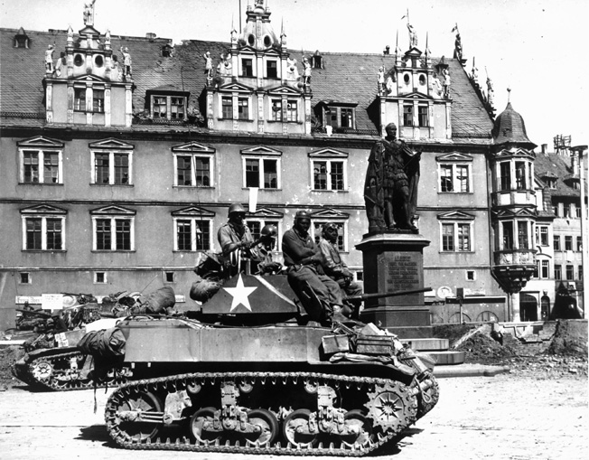 Sitting atop their Stuart light tanks, soldiers of Patton's Panthers wait for orders to enter the town of Coburg, Germany, to clean out pockets of stubborn German resistance.