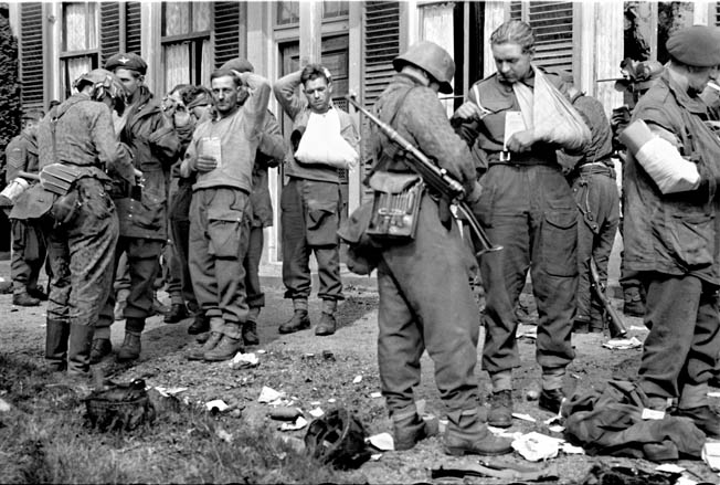German soldiers administer first aid to wounded British airborne troops after their capitulation in Arnhem. The coordinated air and ground offensive of Operation Market-Garden resulted in a costly failure even though some Allied commanders believed it might end the war in Europe by Christmas 1944.