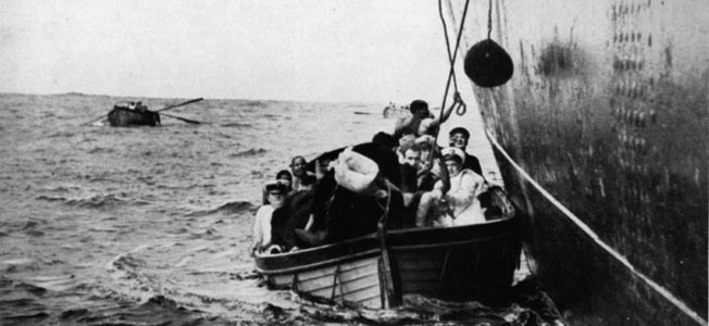 Minutes after the predawn attack by the German raider Atlantis against the Egyptian liner Zam Zam, passengers from the stricken vessel are seen crowding into lifeboats, while the ship itself is listing heavily to port. Atlantis became the most successful of the German surface raiders during World War II.