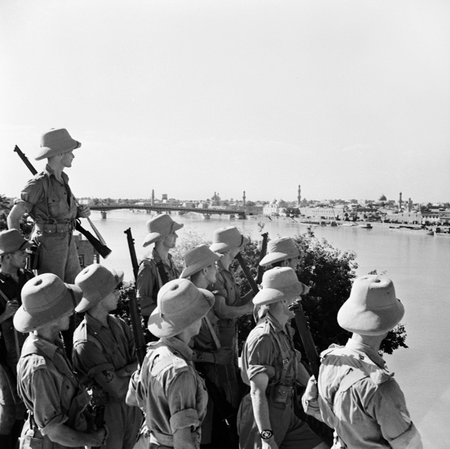 Armed with Enfield rifles, British troops view Baghdad from across the Tigris River, June 1941.