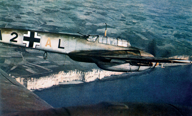 Flying above the famed white cliffs of Dover and the English Channel, a twin-engine Messerschmitt Me-110 of the Luftwaffe provides escort duty to German bombers.