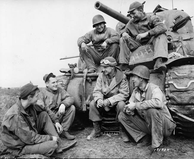 Newspaper columnist Ernie Pyle (bottom) visits with a tank crew of the 191st Tank Battalion at the Anzio beachhead in the spring of 1944. Pyle was beloved by common soldiers because of his realistic reporting on the war.