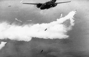 An A-29 Hudson RAF bomber releases its bomb load over Dieppe during the raid while, below, naval craft lay a smoke screen. The British Air Commander decided against high-level bombing of the landing beaches and German defenses the night before the raid. 