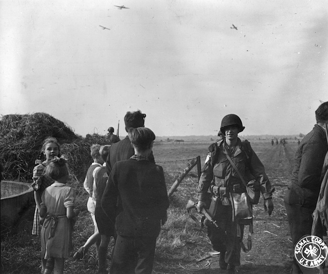 With gliders still visible in the sky, paratroopers of the 101st Airborne Division complete a picture perfect parachute drop into the Netherlands during the opening phase of Operation Market-Garden in September 1944.