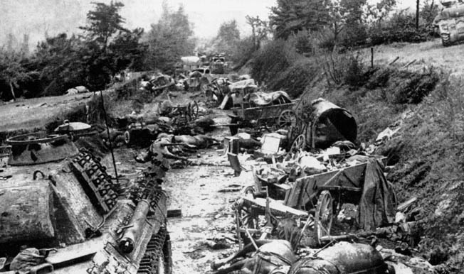 Scene of mass slaughter: Dead men, horses, and destroyed vehicles of all types lie scattered where Allied artillery and aircraft turned a bucolic, narrow lane into the “Corridor of Death.”