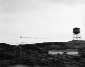Trailing smoke, a stricken Japanese aircraft appears headed for a crash during the raid on Dutch Harbor. The opening shots of the Battle of Midway were fired in the Aleutians.