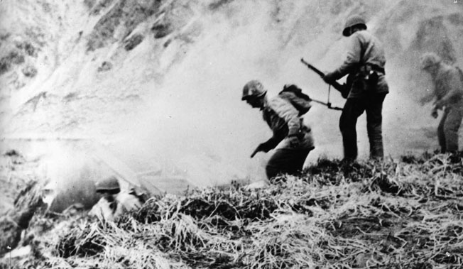 An American combat patrol goes in search of Japanese holed up in dugouts on Attu, May 1943. 