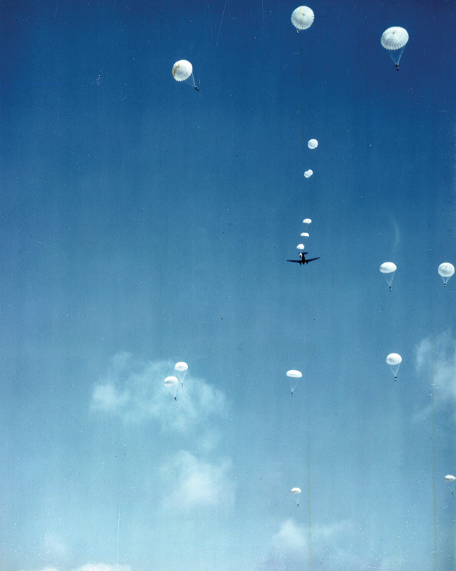 Dotting the sky, men of the 82nd Airborne exit a C-47 transport aircraft and descend earthward. 