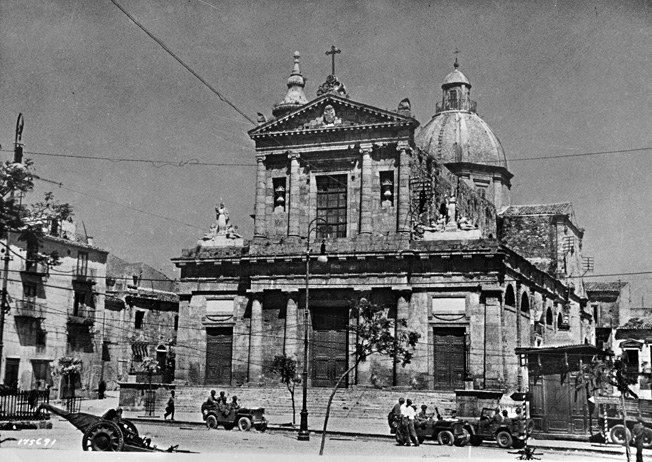 The cathedral in the central area of Gela was one of the first buildings captured by U.S. Army Rangers during operations on the island of Sicily. American troops can be seen moving around outside the cathedral near an abandoned Italian antitank weapon.