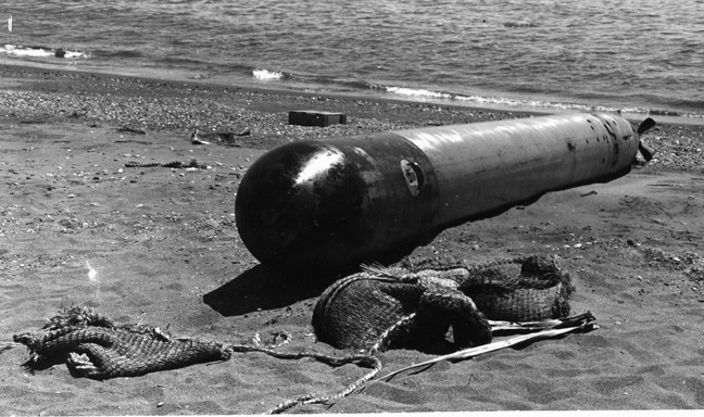 Apparenlty fired by a Japanese submarine under attack by U.S. forces, this Japanese torpedo failed to find a target or to explode and came to rest on the beach near the entrance to a U.S. naval facility at Guadalcanal.