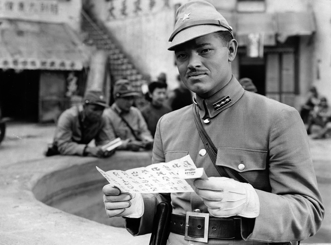 Actor Tom Neal appears in the role of a Japanese soldier in the film Behind the Rising Sun. Hollywood makeup artists have worked their magic to help the actor appear Japanese.