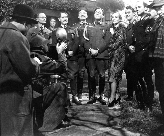 Jeck Benny and Carole Lombard (center) played staring roles in a farce titled To Be or Not to Be, which was directed by Ernst Lubitsch and appeared in theaters in 1942.