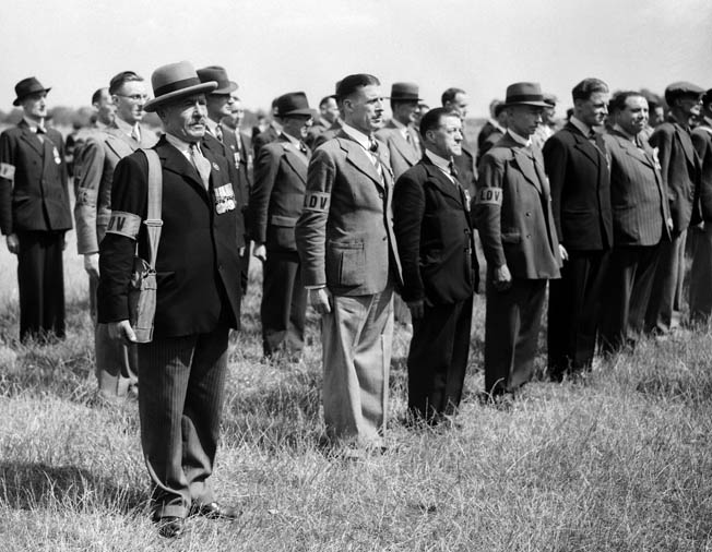 Originally called the Local Defense Volunteers, members of the Home Guard, some of whom served in the British armed forces during World War I, stand in ranks prior to inspection in July 1940. 