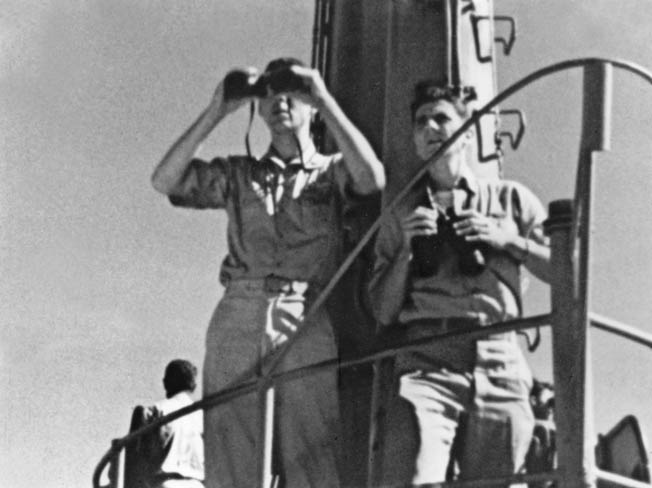 While filming his Academy Award-winning documentary on the Battle of Midway, Ford and an assistant observe the action during a Japanese air raid against Midway Atoll in the Pacific. 