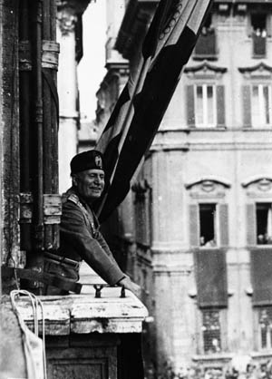 Dressed in full military uniform, a beaming Mussolini appears confident and resolute before a crowd of admirers.