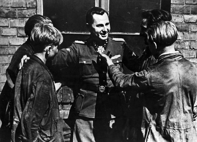 Belgian Nazi Leon Degrelle, a highly decorated combat veteran, talks with factory workers in his native country.